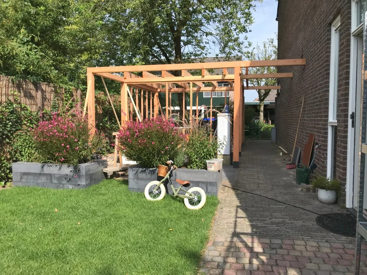 Vrijstaande houten schuur in de achtertuin van een woning